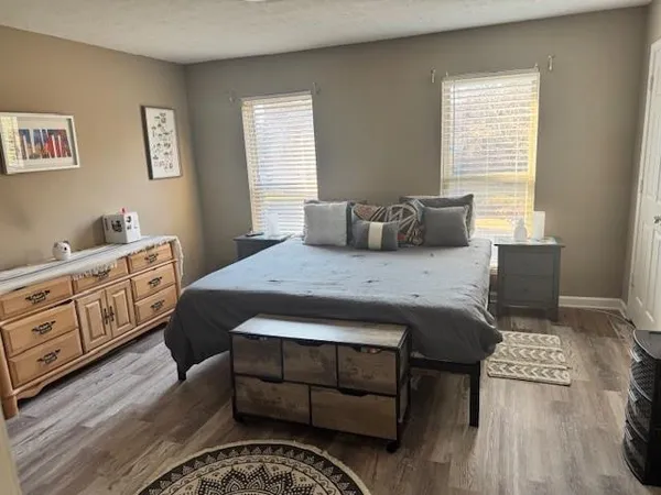 a bedroom with a bed and wooden floor