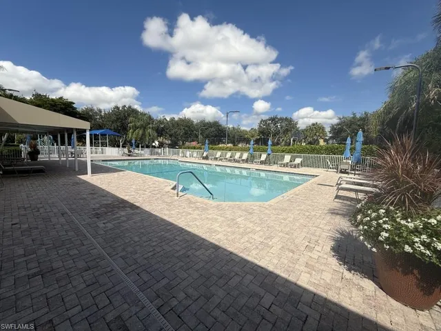 a view of a patio with table and chairs under an umbrella
