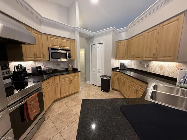 a kitchen with granite countertop a sink stainless steel appliances and cabinets