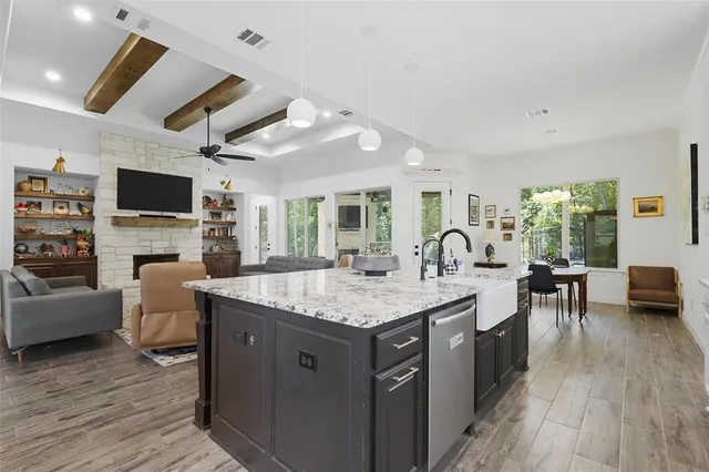 a large kitchen with stainless steel appliances granite countertop a stove and a wooden floors