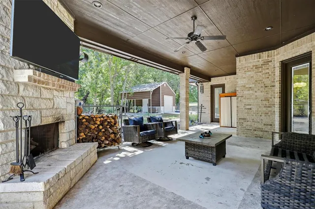 a living room with furniture a fireplace and a floor to ceiling window