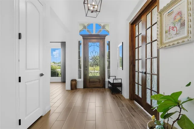 a view of a hallway with wooden floor and entryway