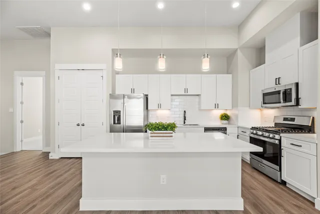a kitchen with stainless steel appliances a refrigerator sink and white cabinets