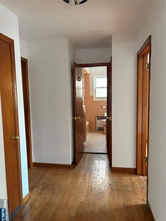 a view of a hallway with wooden floor and a living room