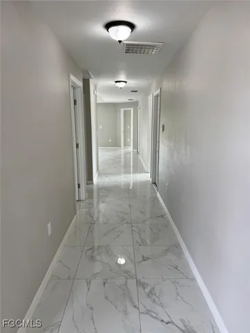 en empty room with window and chandelier fan