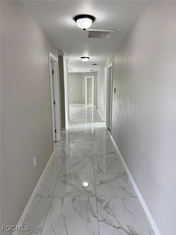 610 Alabama Road South Lehigh Acres, FL 33974 - Photo 4 of 12 en empty room with window and chandelier fan