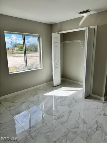 an empty room with windows and closet