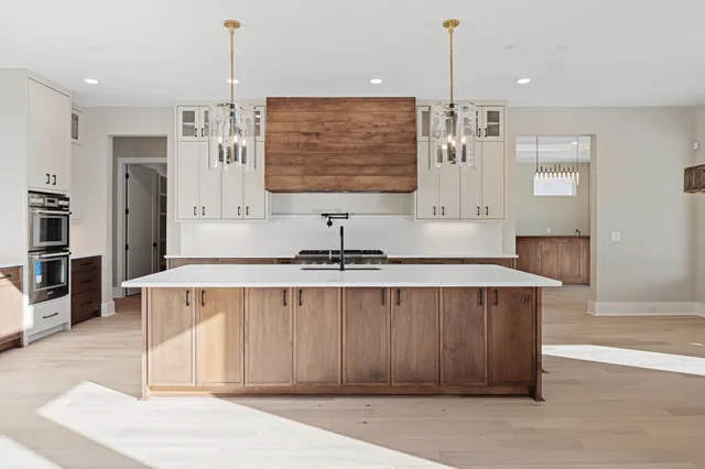a kitchen with kitchen island a sink stainless steel appliances and cabinets
