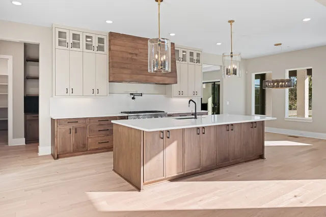 a kitchen with stainless steel appliances granite countertop a stove a sink and a refrigerator