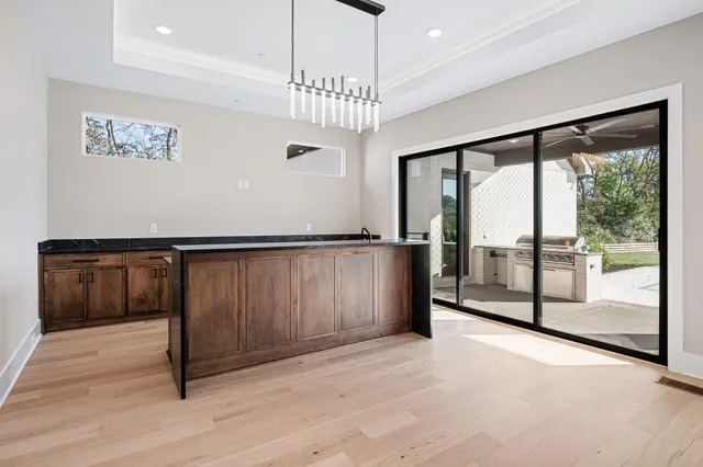 a view of a hallway with wooden floor and chandelier