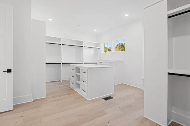 an empty room with windows and closet