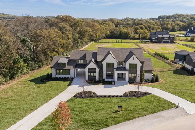 an aerial view of a house with swimming pool garden and trees