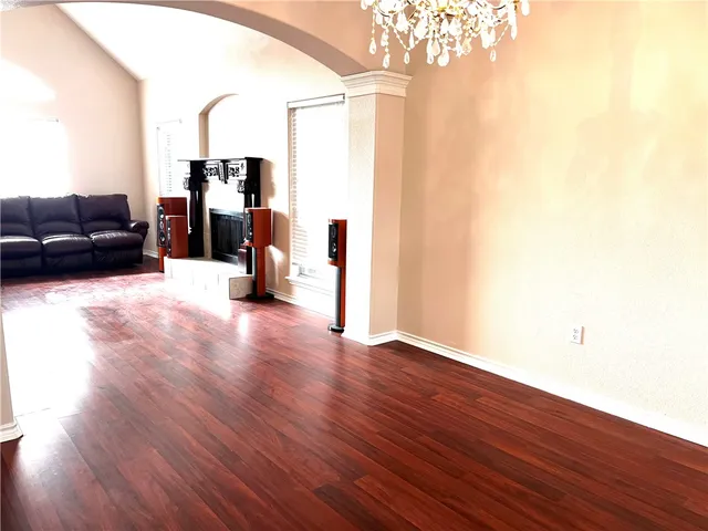 a view of a room with white cabinets and wooden floor