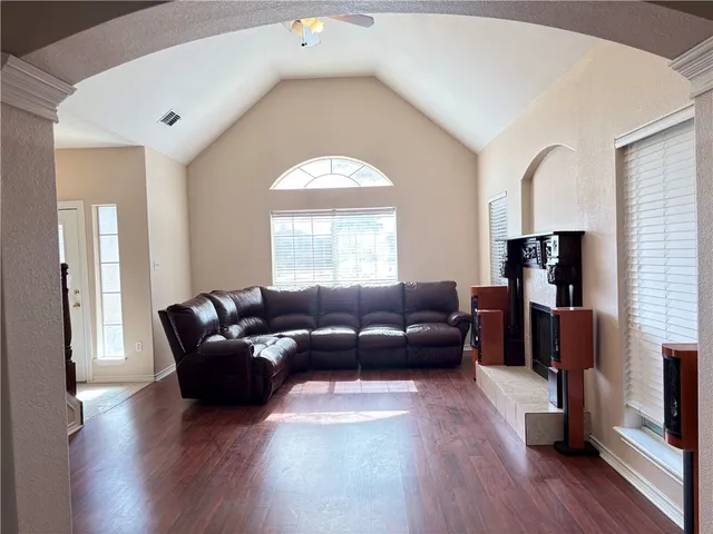 a living room with fireplace furniture and a wooden floor
