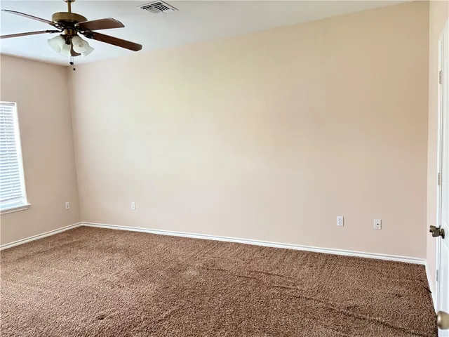 an empty room with a ceiling fan and a window