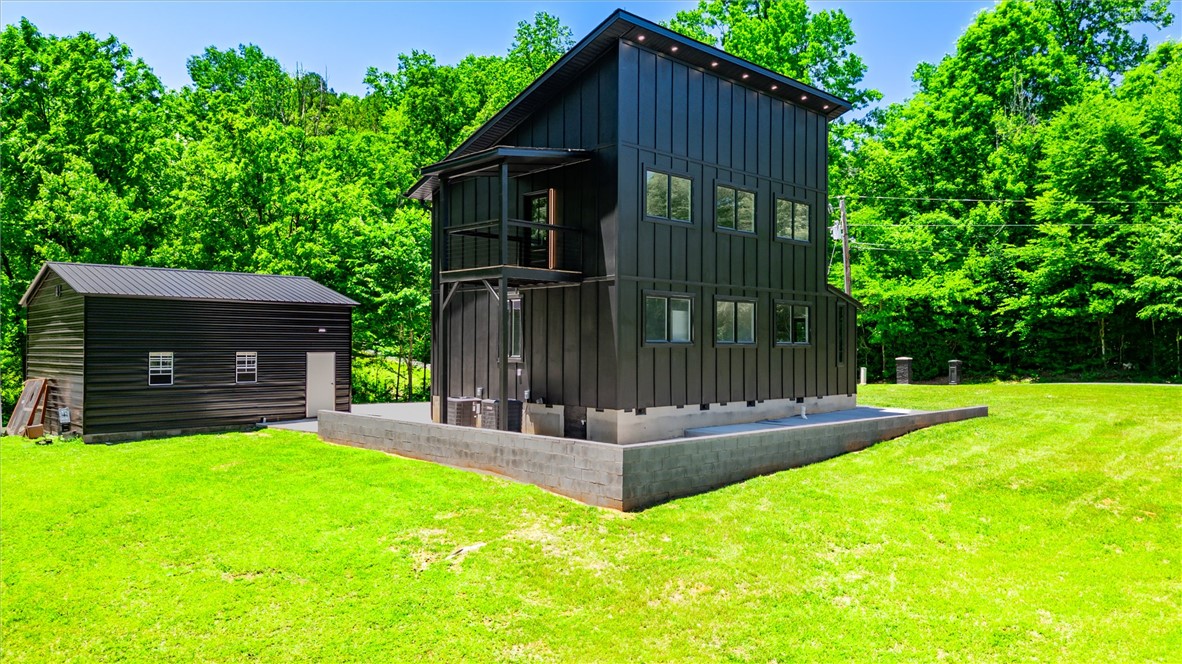159 Cherokee Trail Easley, SC 29640 - Photo 38 of 38 Modern architecture meets nature, featuring a striking black facade against a lush green backdrop.