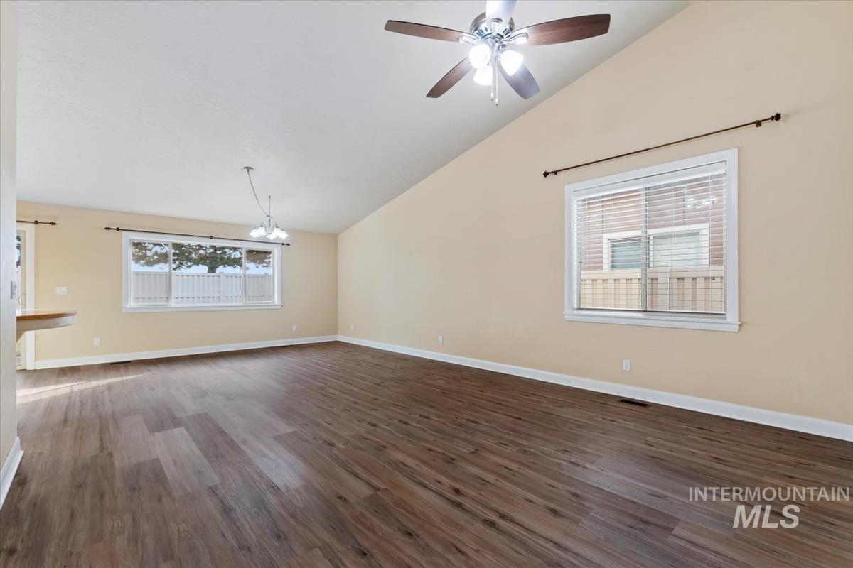 1838 Ridge Way Middleton, ID 83644 - Photo 11 of 42 Unfurnished living room with vaulted ceiling, dark wood finished floors, a chandelier, and ceiling fan