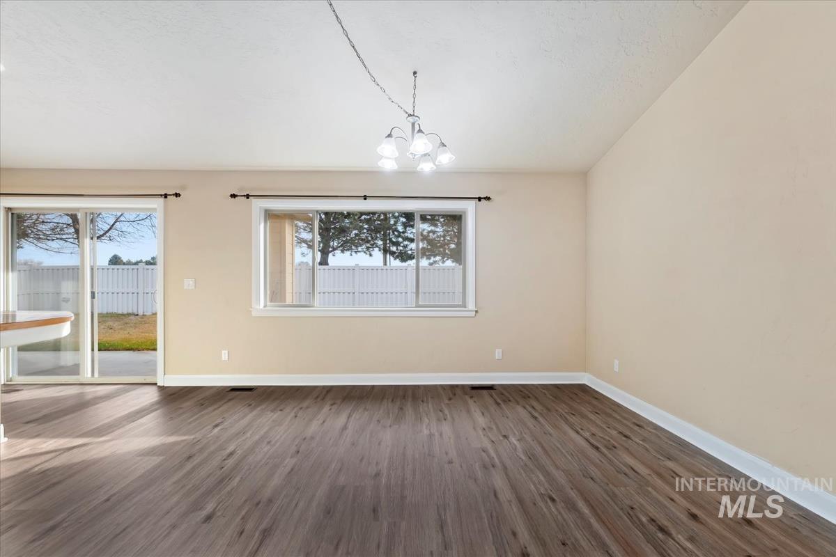1838 Ridge Way Middleton, ID 83644 - Photo 14 of 42 Unfurnished dining area with dark wood-style flooring, a chandelier, plenty of natural light, and lofted ceiling