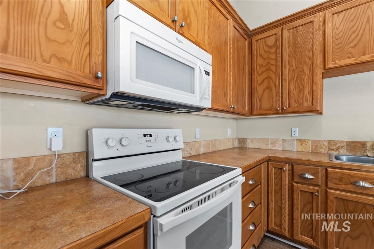 1838 Ridge Way Middleton, ID 83644 - Photo 20 of 42 Kitchen with white appliances, brown cabinetry, and light countertops
