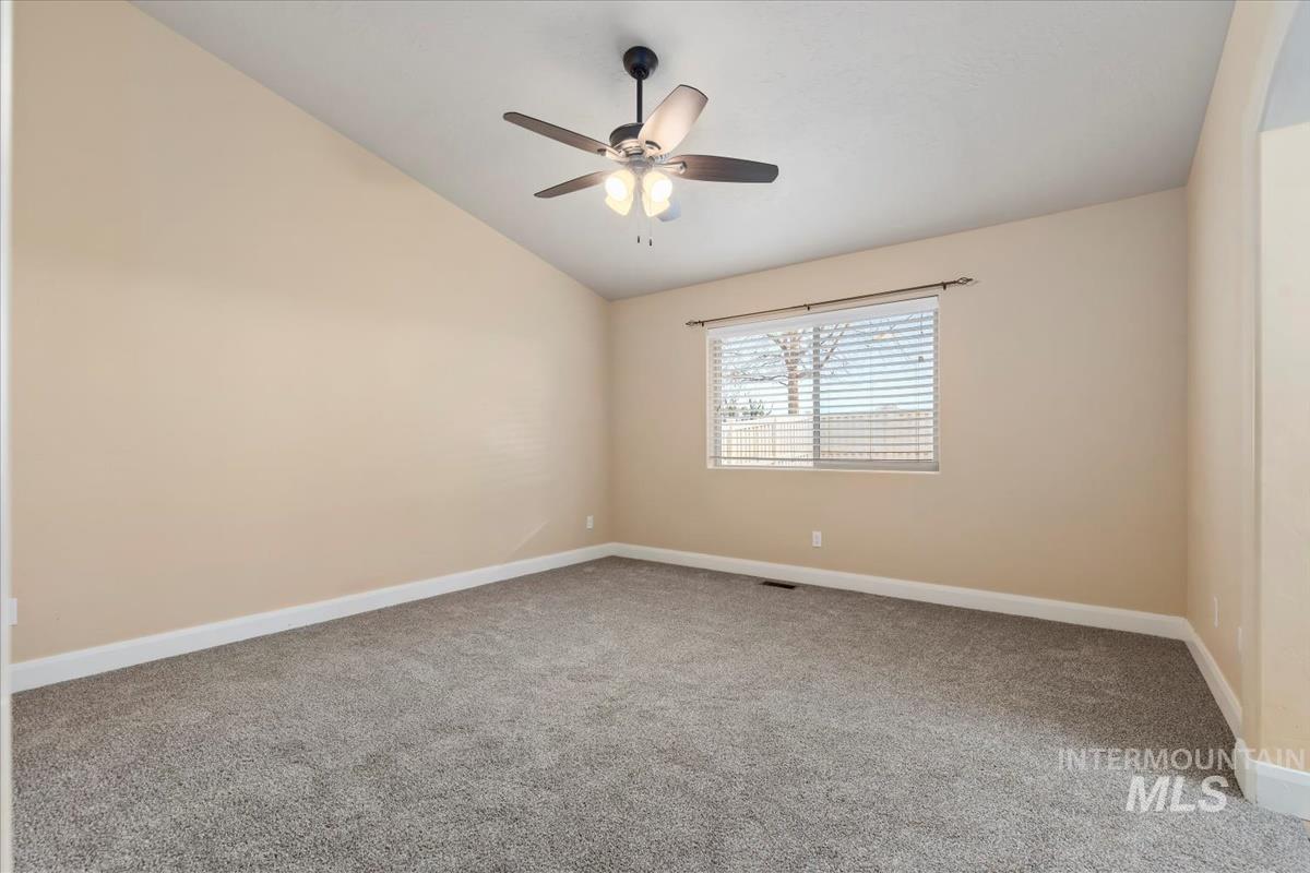 1838 Ridge Way Middleton, ID 83644 - Photo 27 of 42 Empty room with light carpet, lofted ceiling, and ceiling fan