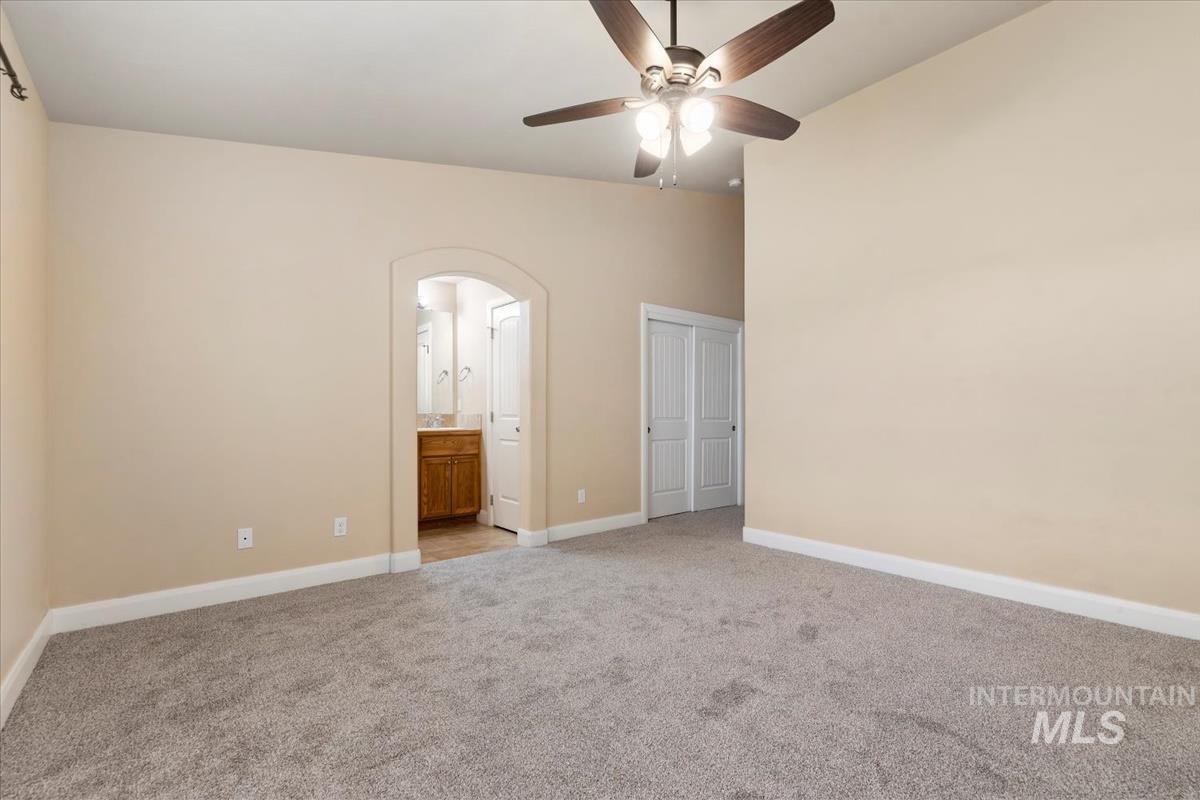 1838 Ridge Way Middleton, ID 83644 - Photo 29 of 42 Unfurnished bedroom with light carpet, arched walkways, connected bathroom, and ceiling fan