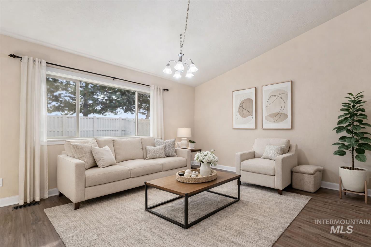 1838 Ridge Way Middleton, ID 83644 - Photo 3 of 42 Living room featuring a chandelier, vaulted ceiling, and dark wood-style flooring