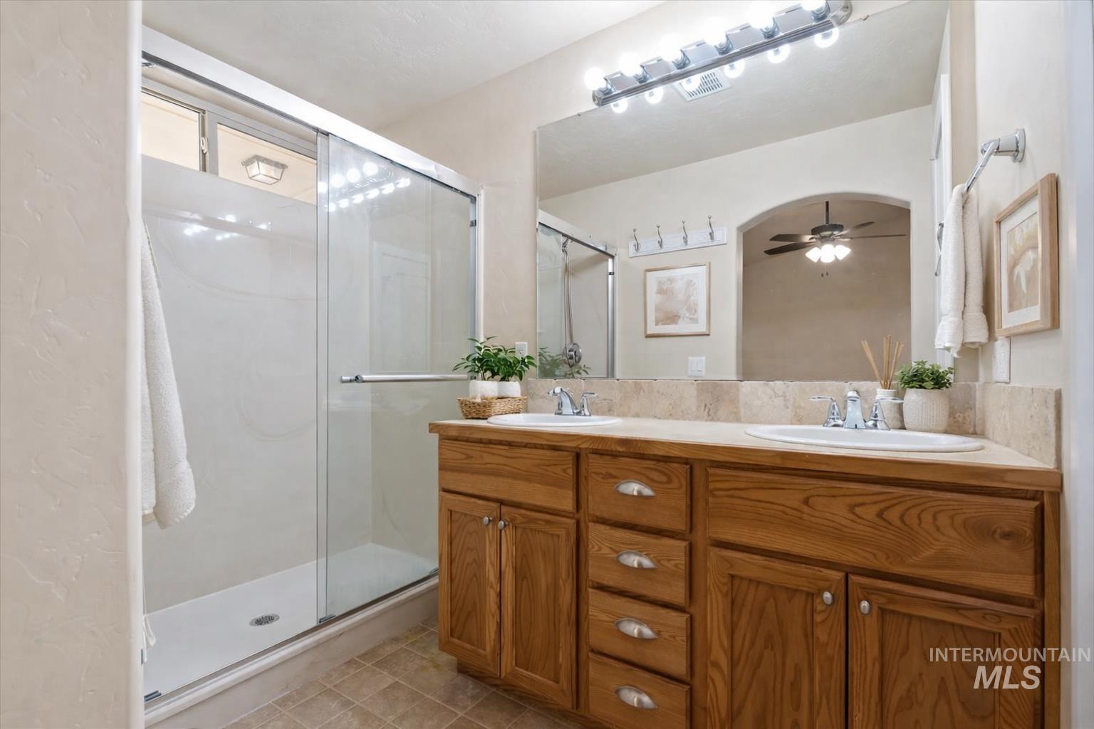 1838 Ridge Way Middleton, ID 83644 - Photo 8 of 42 Bathroom featuring double vanity, a shower stall, a ceiling fan, and light tile patterned floors