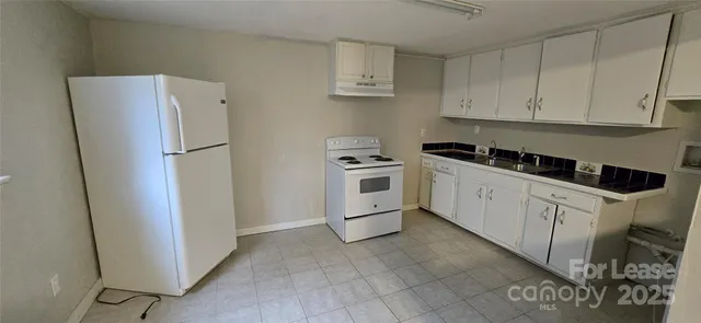 a kitchen with white cabinets and white appliances