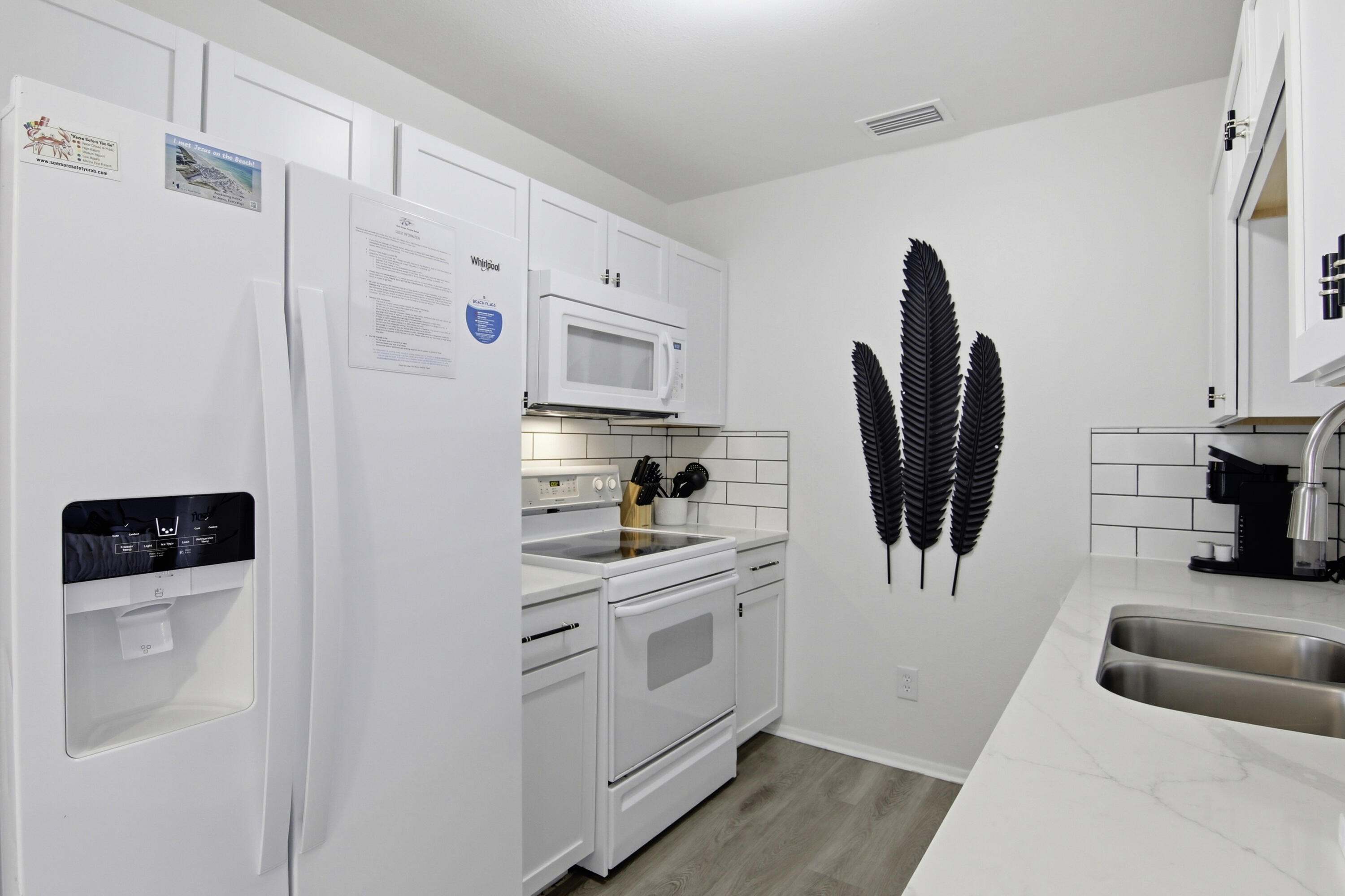 64 Cross Creek Road, Unit 28D Miramar Beach, FL 32550 - Photo 17 of 34 a kitchen with white cabinets and a refrigerator
