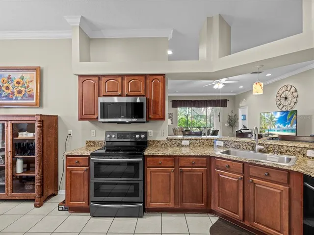 a kitchen with stainless steel appliances granite countertop a stove top oven a sink dishwasher and a refrigerator