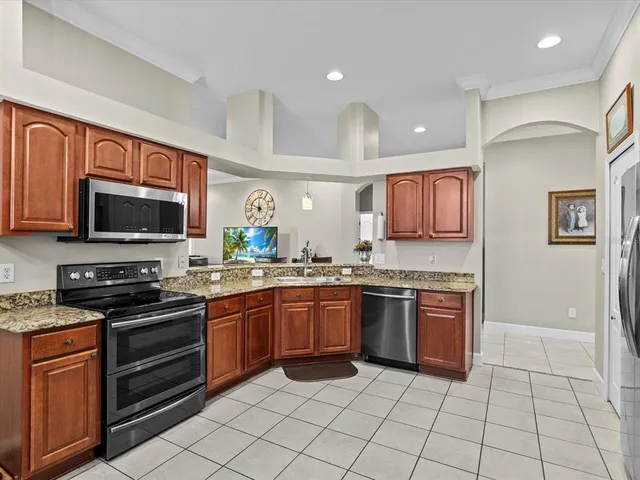 a kitchen with stainless steel appliances granite countertop a sink stove and refrigerator
