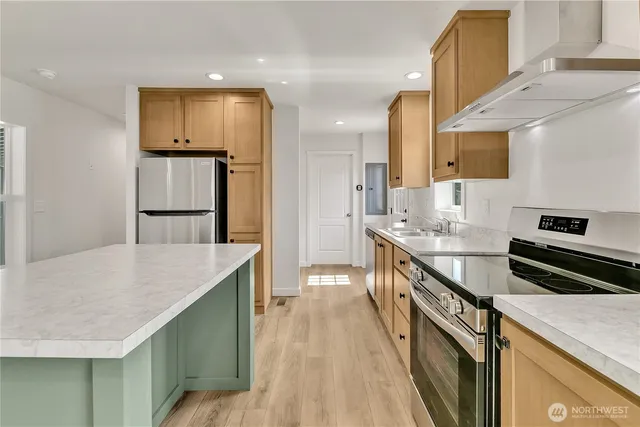 a kitchen with granite countertop a sink stainless steel appliances and cabinets