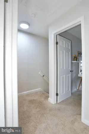 a view of a livingroom with wooden floor and a bathroom