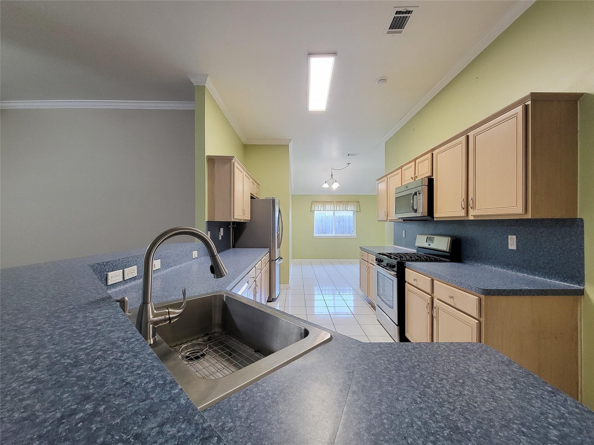 23327 Sandpiper Trail Spring, TX 77373 - Photo 11 of 22 a kitchen with stainless steel appliances granite countertop a sink a stove top oven a chimney and a center island