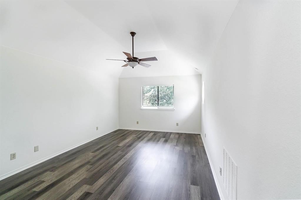 1905 Lansdown Court Carrollton, TX 75010 - Photo 14 of 23 an empty room with a wooden floor and windows