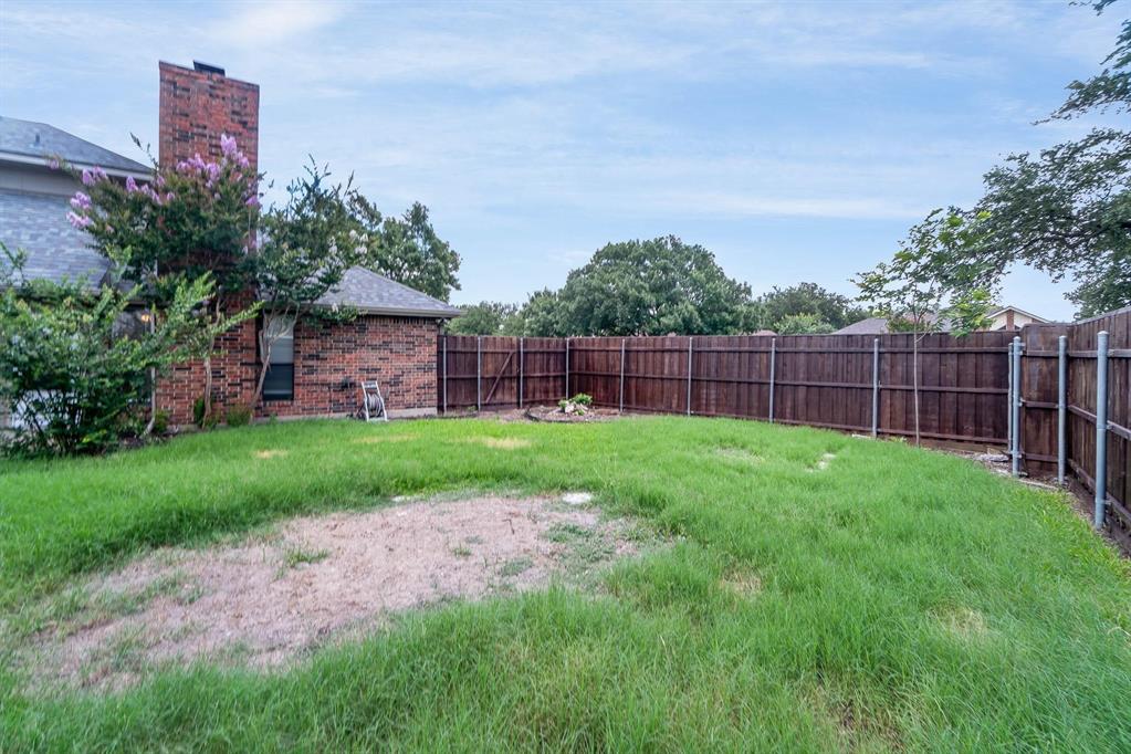 1905 Lansdown Court Carrollton, TX 75010 - Photo 22 of 23 a view of a yard with a wooden fence