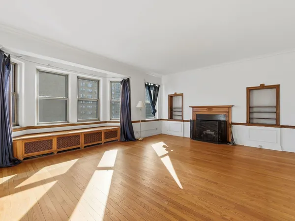 a view of an empty room with window and cabinet