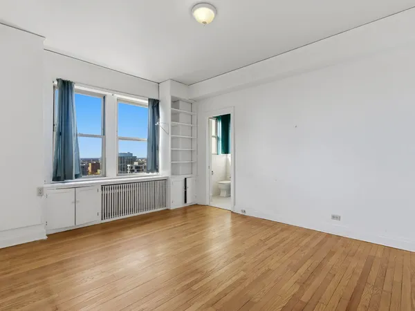 a view of a kitchen with wooden floor and a window
