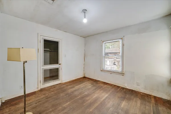 an empty room with windows and closet