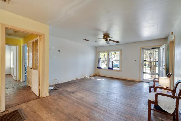an empty room with wooden floor and windows