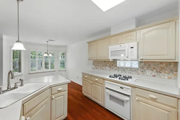 a kitchen with granite countertop white cabinets and white appliances