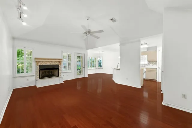 a view of empty room with wooden floor and fireplace