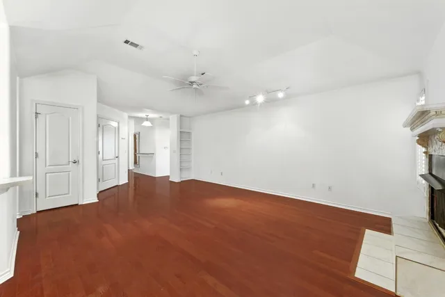 a view of empty room with wooden floor