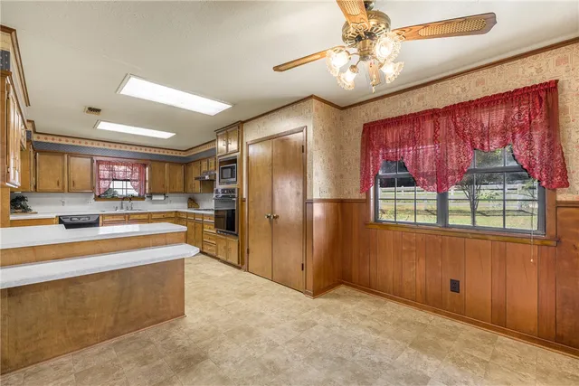 a large kitchen with stainless steel appliances granite countertop a refrigerator and a sink