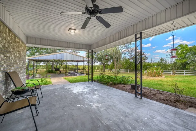 a view of a patio with a table chairs and a backyard