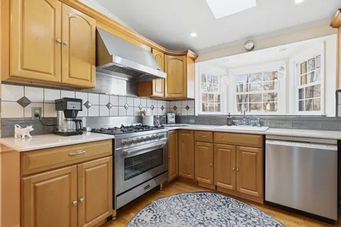 a kitchen with stainless steel appliances granite countertop a sink stove and cabinets