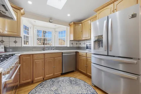 a kitchen with stainless steel appliances granite countertop a sink stove and refrigerator