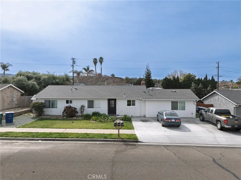 a view of house with a garden and parking space