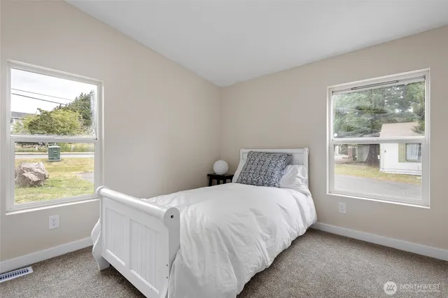 a bedroom with a bed and a large window