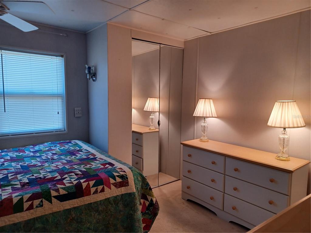 34701 Rosebud Row Zephyrhills, FL 33541 - Photo 5 of 12 a bedroom with a bed and a lamp on dresser